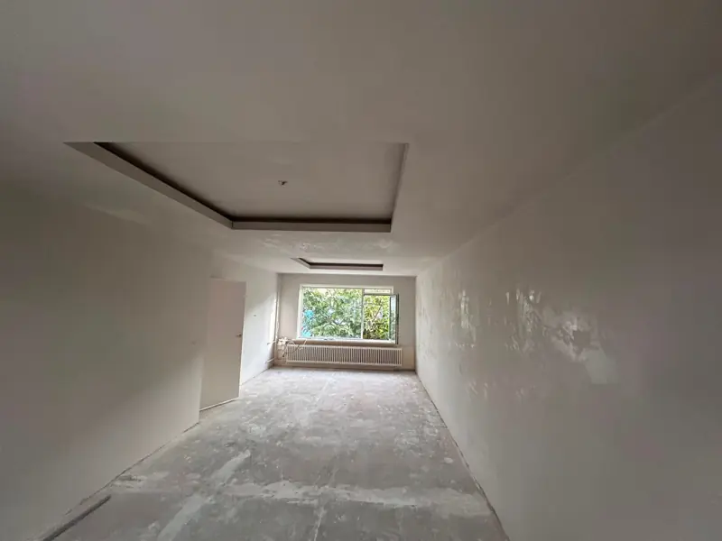 Lange ruimte met verlaagd plafond en strakke wanden