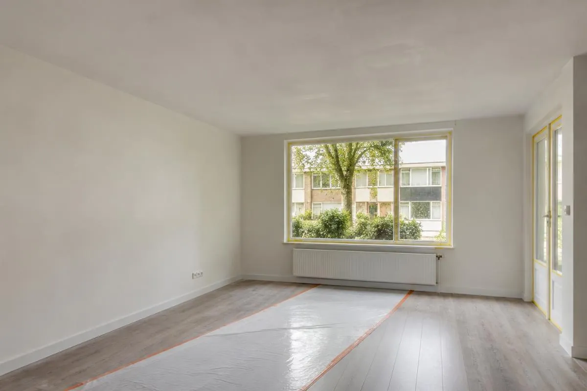 Woonkamer met sausklaar gestuct plafond en stucloper op de vloer