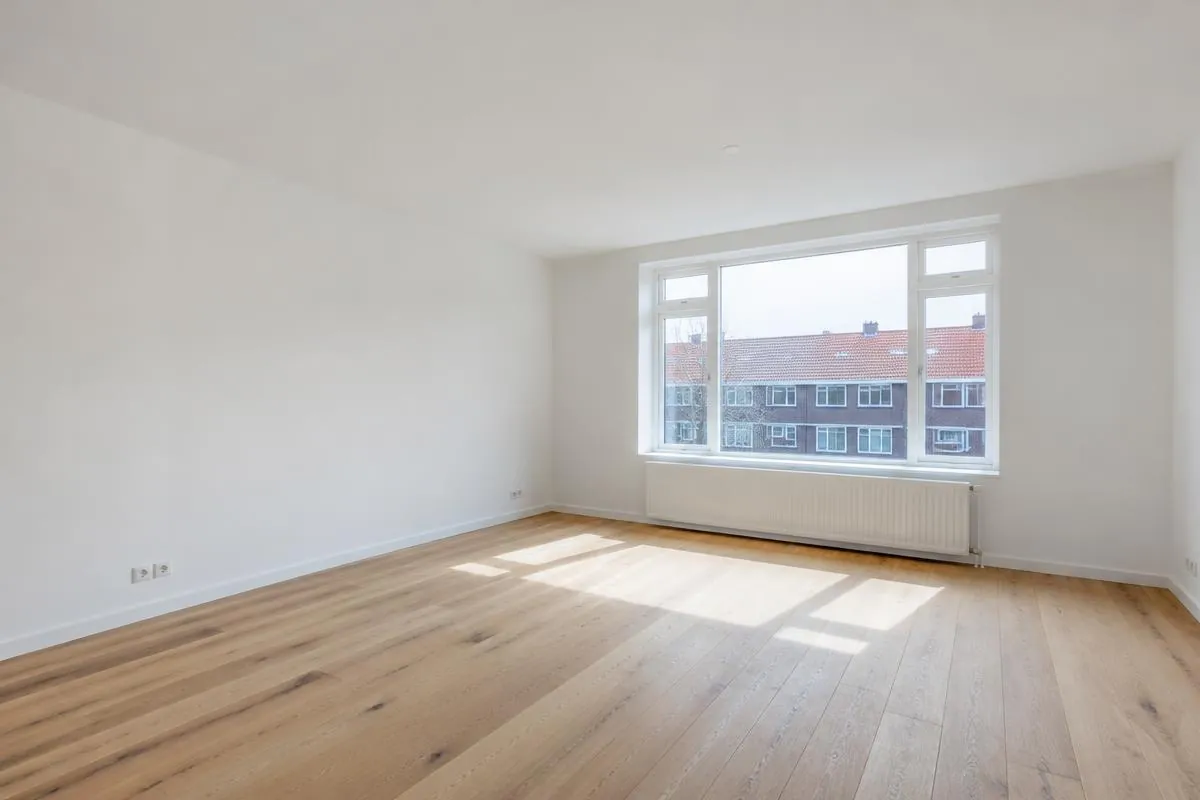 Lege woonkamer met sausklaar gestucte witte wanden