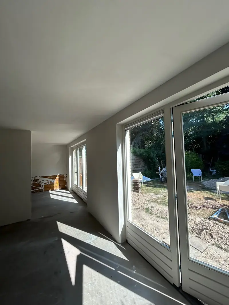 Woonkamer met wanden en plafond sausklaar en grote openslaande deuren